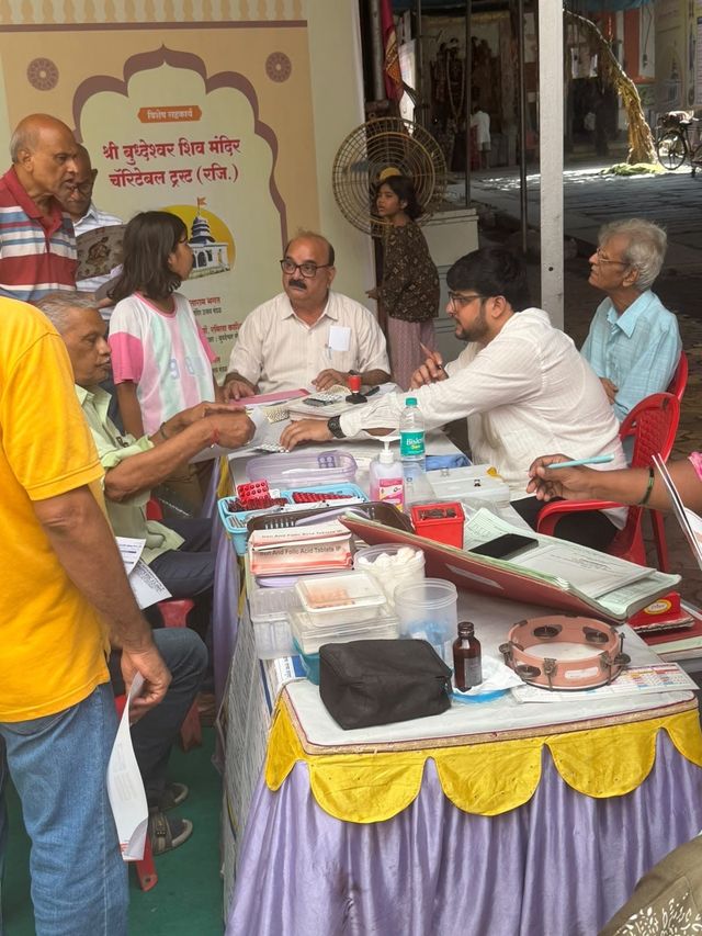 Volunteers and doctors seated together at the consultation table, reviewing forms with attendees