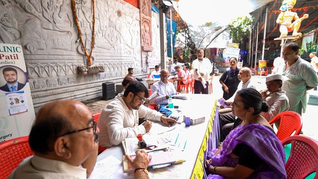 Dr. Adarsh Patil and volunteers attending to an attendee at the consultation table during the camp