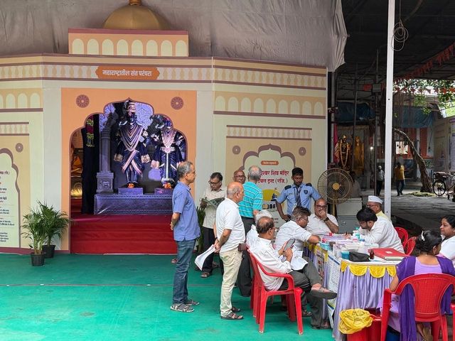 Another view of the temple stage and registration area, with volunteers and attendees at the consultation table